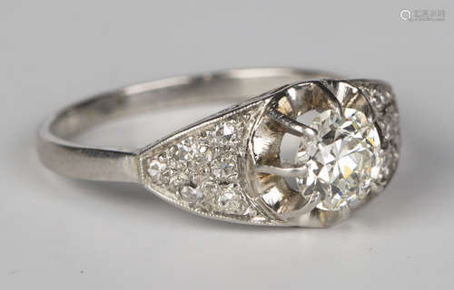 A French platinum and diamond ring, claw set with a circular cut diamond between diamond set