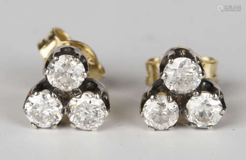 A pair of gold and diamond three stone cluster earrings, claw set with circular cut diamonds, with