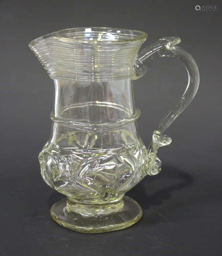 A glass cream jug, mid-18th century, the low bellied body with coiled thread decoration to the rim