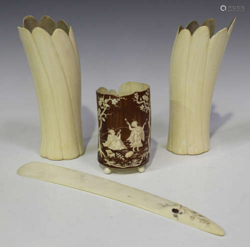 A Japanese stained and incised ivory tusk vase, early 20th century, the brown stained exterior