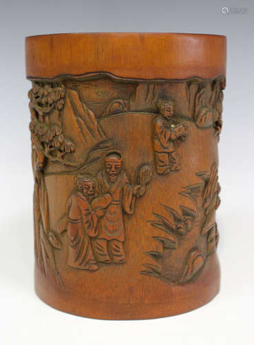 A Chinese bamboo brushpot, 20th century, carved in relief with figures and pines, divided by