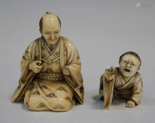 A Japanese carved ivory okimono figure group, Meiji period, modelled as a kneeling father and son,