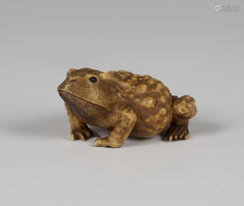 A Japanese carved staghorn okimono, Meiji period, finely modelled in the form of a toad, unsigned,