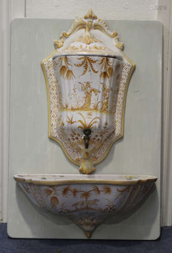 A French faience wall cistern with domed cover and matching basin, late 19th century, the shield