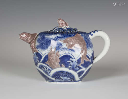 A Japanese underglaze blue and red porcelain teapot and cover by Makuzu Kozan, Meiji period, of oval