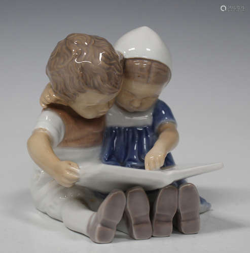 A Bing & Grondahl porcelain figure group, modelled as two children reading a book, underglaze blue