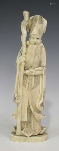 A Japanese ivory okimono carving, Meiji period, modelled as a sage holding a scroll and gnarled