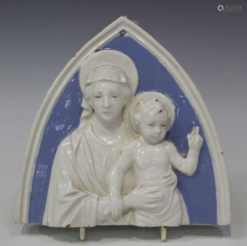 A Cantagalli maiolica wall plaque of arched form, relief decorated with the Madonna and Child