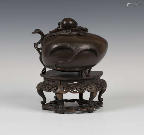A Chinese brown patinated bronze peach censer and cover, late Qing dynasty, the peach-form body