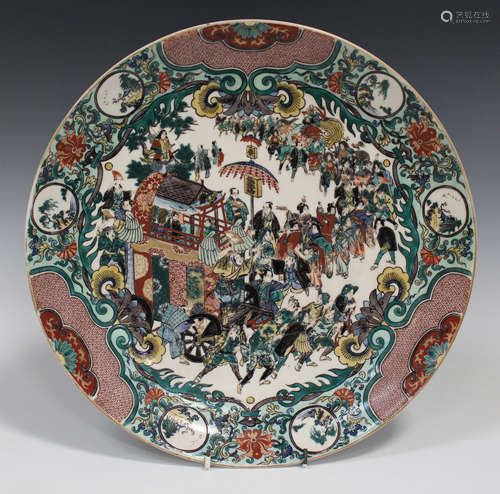 A Japanese Kutani circular dish, Meiji period, the centre painted with a processional scene of