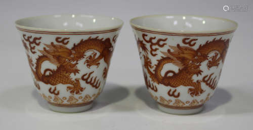 A pair of Chinese iron red decorated porcelain wine cups, mark of Tongzhi and possibly of the