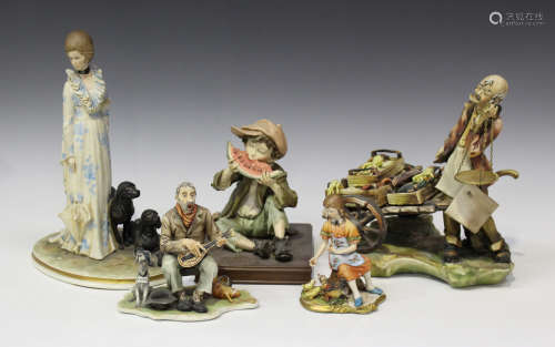 A collection of mostly Capodimonte porcelain figures, 20th century, including a boy eating a