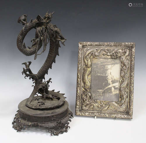 A Japanese metal figure of a coiling dragon on a crashing wave moulded circular base, height 41cm (