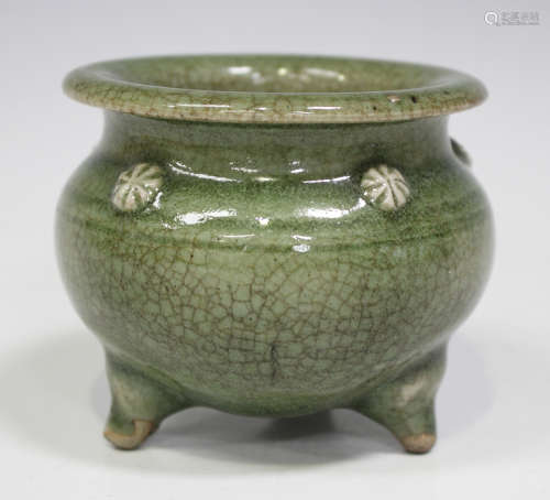 A Chinese celadon glazed pot, the squat globular body with applied foliate roundels beneath a flared