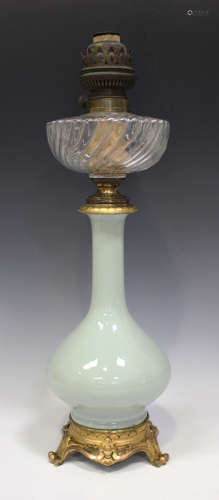 A Chinese celadon glazed porcelain bottle vase oil lamp base with gilt metal mounts and glass
