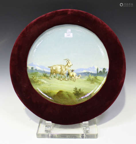 A Continental pottery charger, early 20th century, painted with goats within a landscape, painted