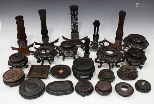 A collection of forty-three Chinese wood stands, late 19th and 20th century, including circular