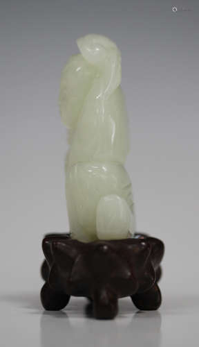 A Chinese pale celadon jade carving, probably 20th century, modelled as a boy kneeling beside a