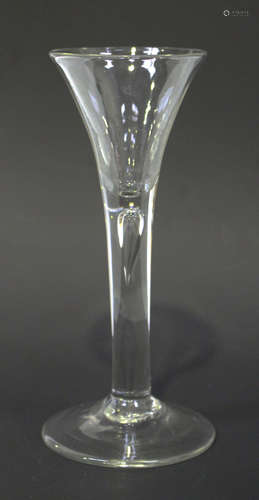 A wine glass, mid-18th century, the drawn trumpet bowl raised on a plain teared stem and conical