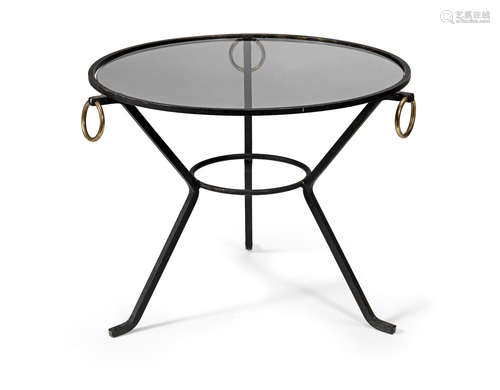 Iron frame with brass ring handles, glass, 60cm diameter x 44.5cm high  Jacques Adnet (French 1900-1984) An occasional table