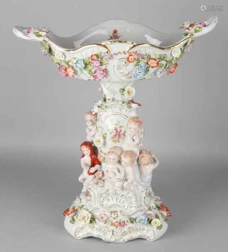 Large porcelain centerpiece with putti and roses + gold decor. 21st century. Size: 47 x 42 x 24