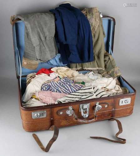 Big lot of antique dolls and children's clothes in leather suitcase. 19th century. Size: 70 x 40 x