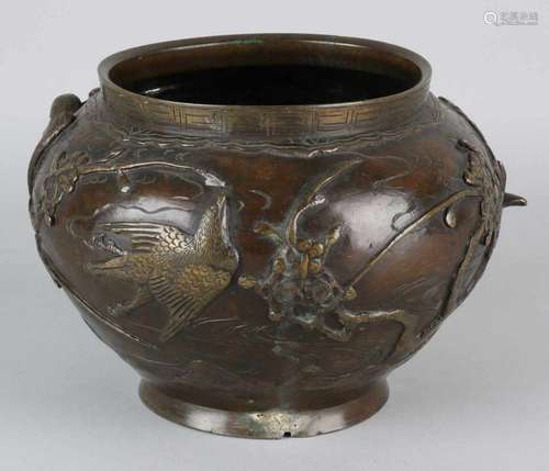 Antique Chinese bronze flower pot with soil mark and floral decor with birds of prey. Circa 1900.