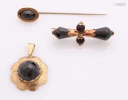 Lot with gold jewelery with garnet, 585/000, a tie pin with oval faceted garnet and base pin, a