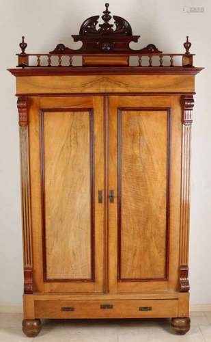 Walnut two-door wardrobe. Underneath two drawers with one drawer and several shelves. On top of a