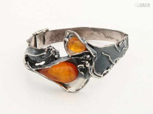 Silver slave band with floral decoration on the upper side flared and set with 2 amber stones. The