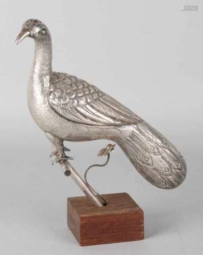 Silver spreader, BWG, in the shape of a peacock on a stick placed on a wooden foot.23x10x7cm ca