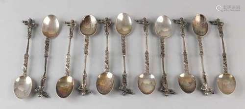 Eleven silver spoons, 833/000, with a carved handle crowned with a pipe-like figure. Total ca 205