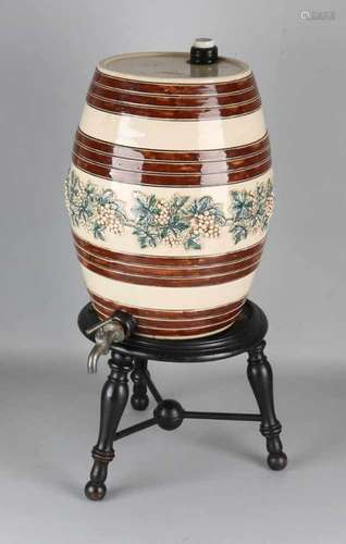 Antique ceramic wine barrel with vines decor around + tap, on wooden base. Size: 61 x 26 cm ø. In