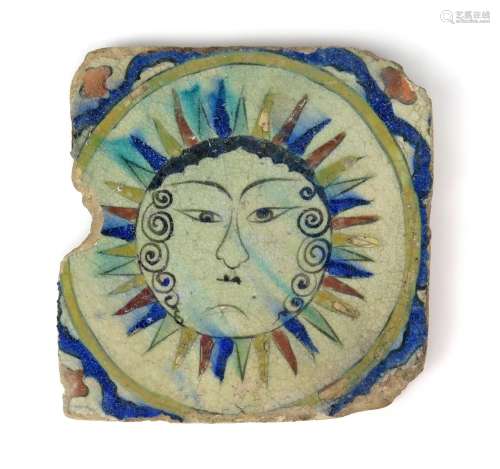 A Kubachi (North Iran) tile probably 19th century, painted with a face within a sunburst in green,