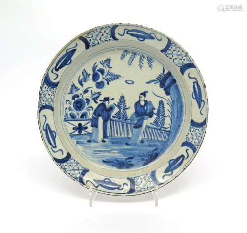 A Bristol delftware shallow dish c.1740, painted in blue with a Chinese lady in a garden being