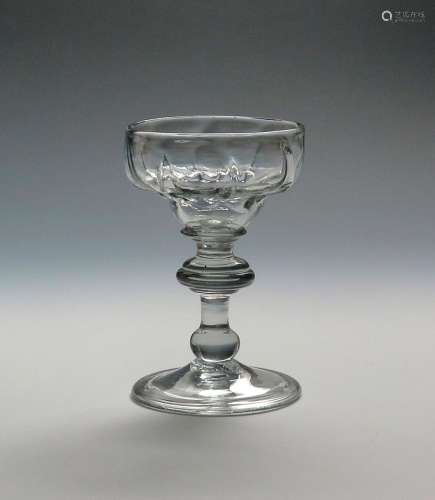 A mead or champagne glass c.1725, with pan-topped moulded bowl above a collar and annulated knop,