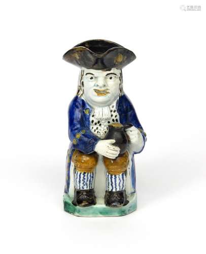 A Pratt ware Toby jug c.1800, seated and resting a foaming jug of ale on his left knee, decorated in