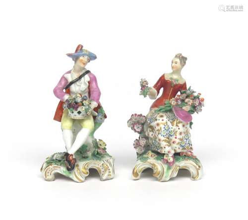 A pair of Chelsea figures of a gallant and his companion c.1760-65, seated, he with a basket of