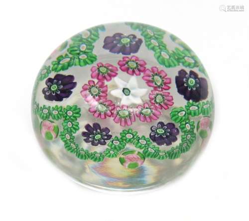 A Clichy spaced paperweight c.1850, set with a flower-shaped garland around a central star cane