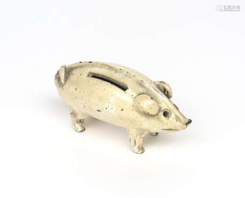 A pottery money box 19th century, modelled as a stylized pig in a pinkish cream glaze, a coin slot