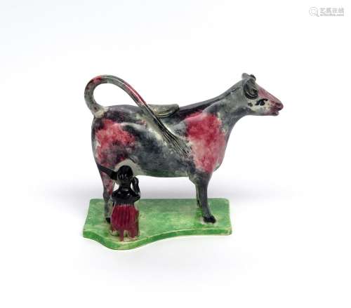 A pearlware cow creamer and cover c.1820-30, the bovine standing four square on a flat shaped