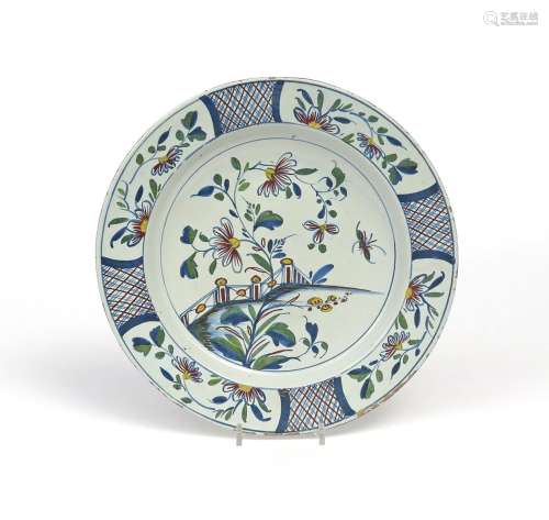 A Bristol delftware charger c.1760, painted in polychrome enamels with an insect flying beside
