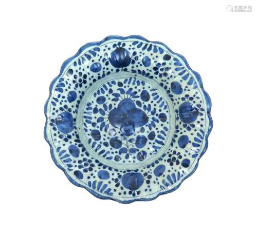 A small lobed delftware dish late 17th century, probably London, decorated with a stylized floral