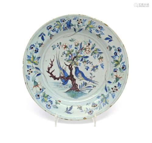 A large delftware charger c.1760, painted in polychrome enamels with two long-tailed birds, one