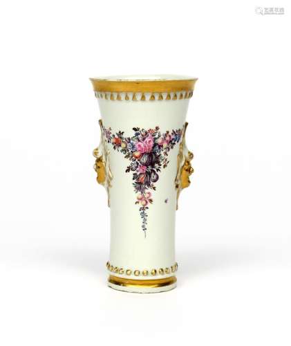 A German porcelain beaker vase mid 18th century, the tall flared form painted with swags of fruit