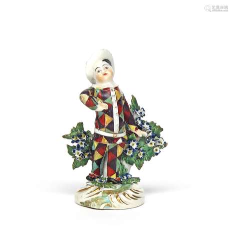 A Derby figure of a child dressed as Harlequin c.1765, holding a slapstick in his left hand, his