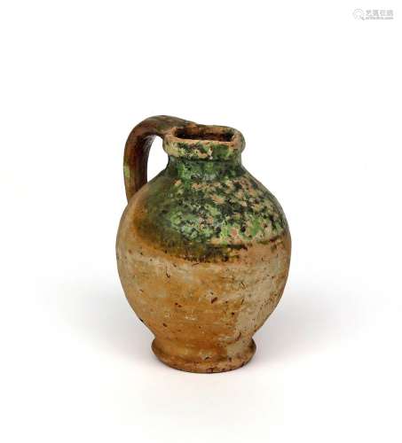 An English earthenware jug possibly 16th/17th century, the upper section decorated in a green glaze,