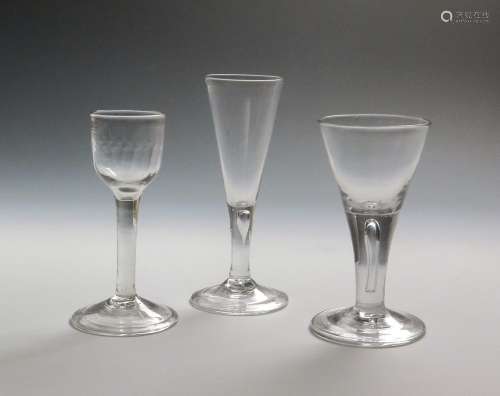 Three wine glasses c.1750-60, two with drawn trumpet bowls rising from plain stems enclosing