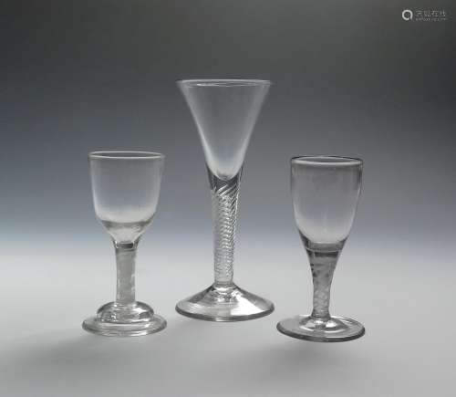 Three wine glasses c.1760-70, the largest with a drawn trumpet bowl on an airtwist stem, the