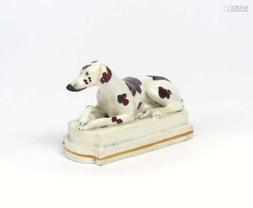 An English porcelain figure of a dog 1st half 19th century, recumbent on a shaped and stepped